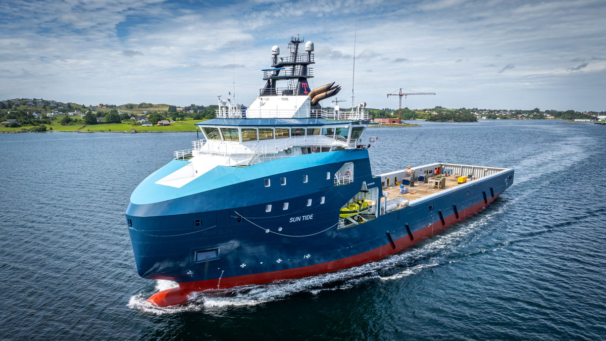 Bilde av et skip på havet med land i bakgrunn