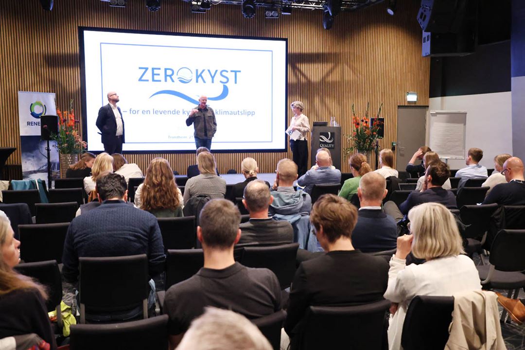 Politisk debatt på en scene, i en konferansesetting.