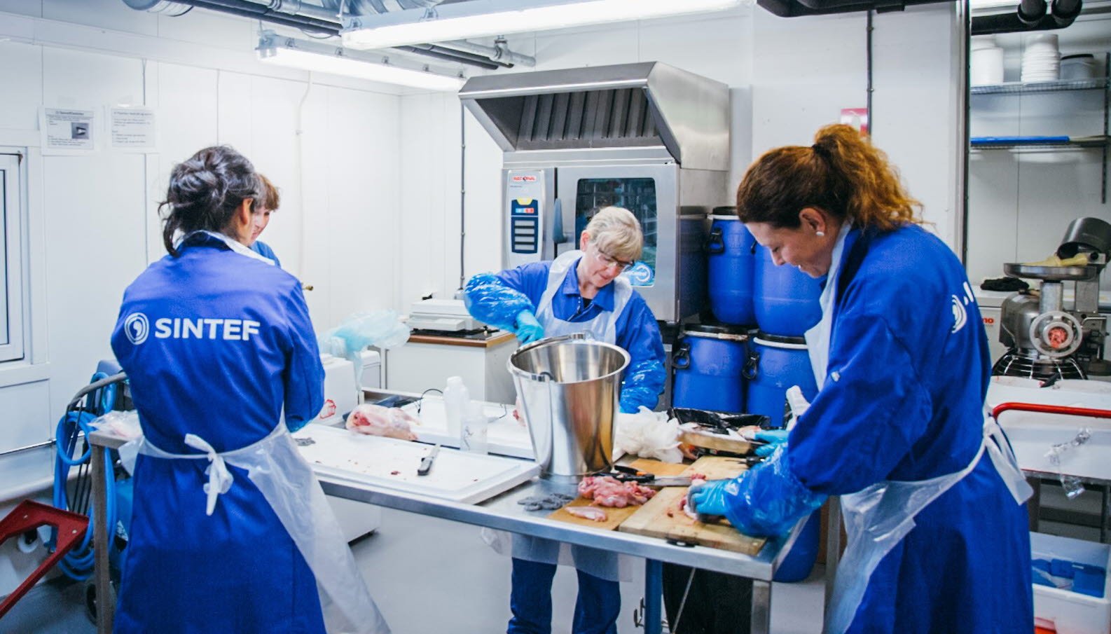 Fire damer rundt et bord på et grovkjøkken