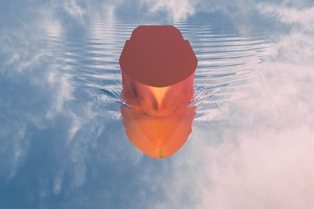 Oransj modellbåt på stille vann