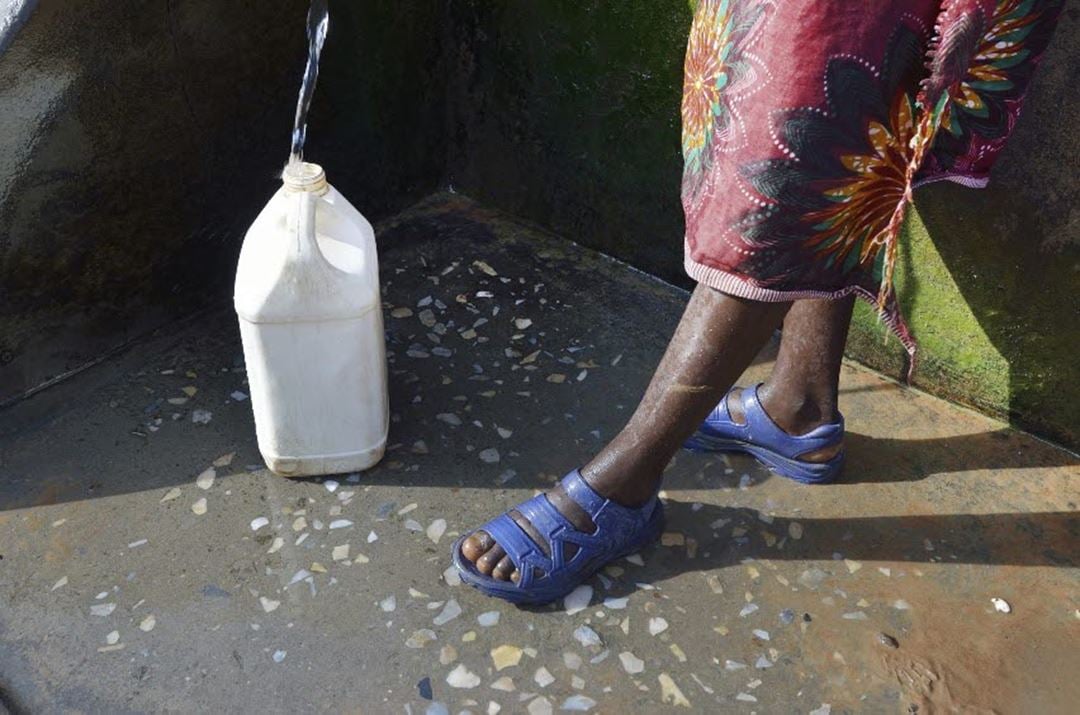 Plastkanne fylles med vann av ghanesisk kvinne. Illustrasjonsfoto: Thinkstock.