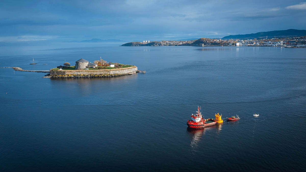 Overview photo of Trondheim Fjord showing Munkholmen islet and a red boat.