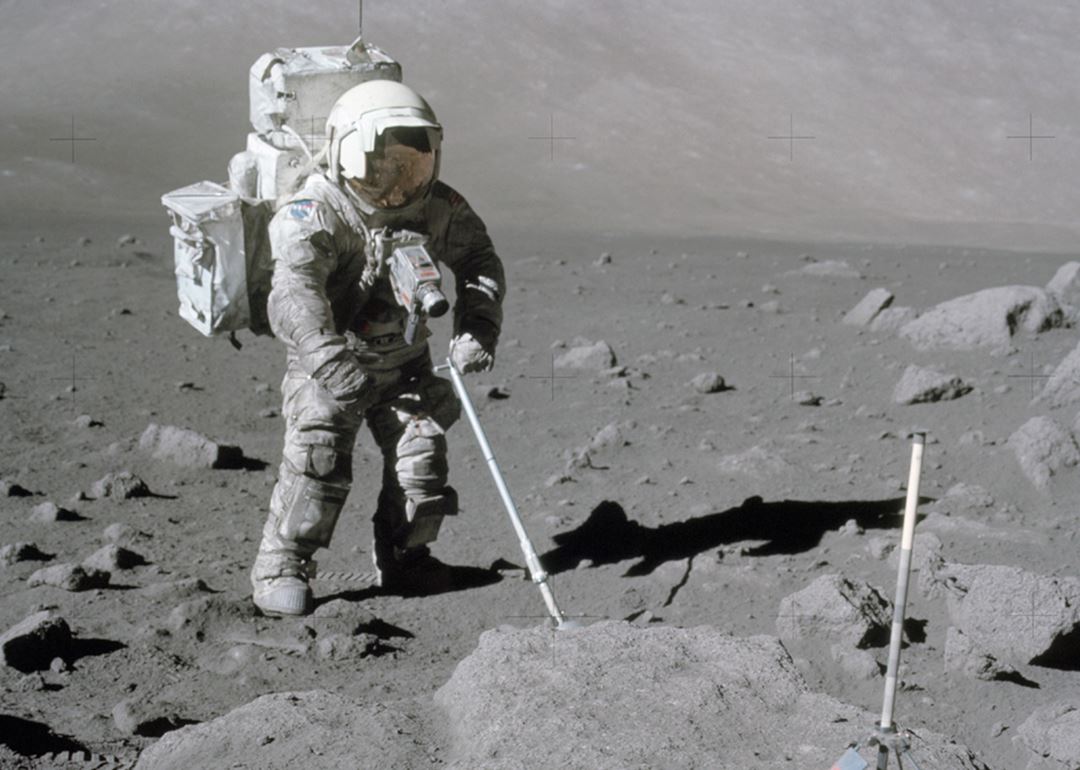 En astronaut i romdrakt samler steiner på månen