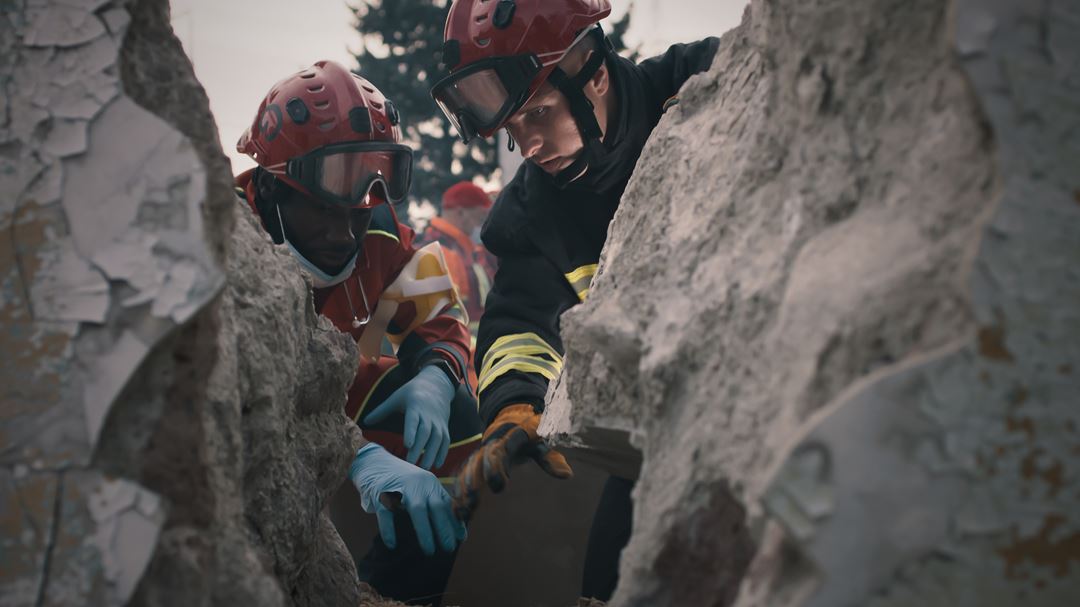 To redningsarbeidere ser ned i en fjellsprekk