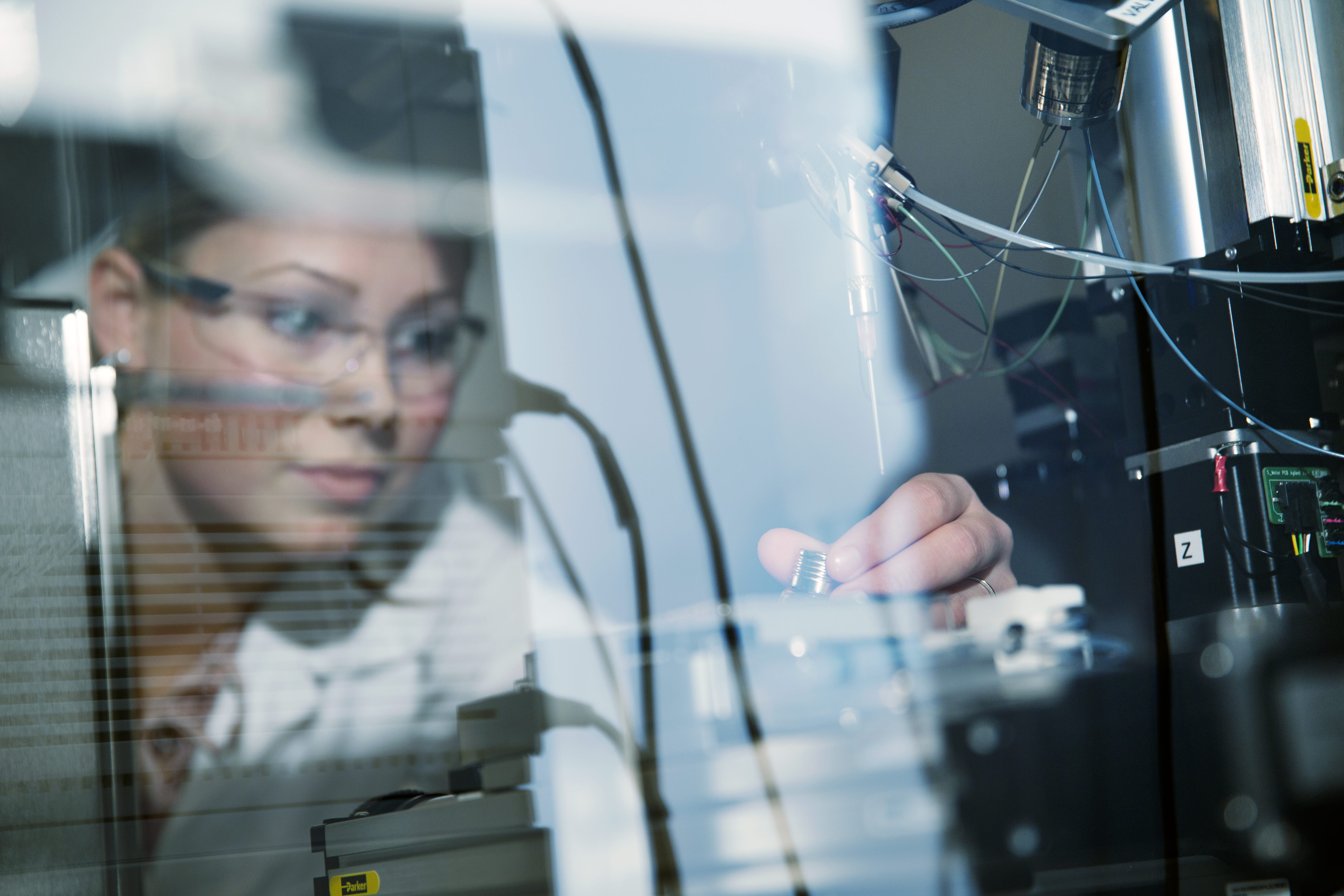 Female researching scientist wearing protective glasses in a lab