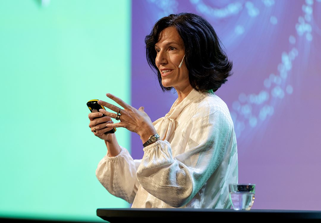 Kimberly Mathisen står på scenen og snakker. Foto: Stine Østby/SINTEF