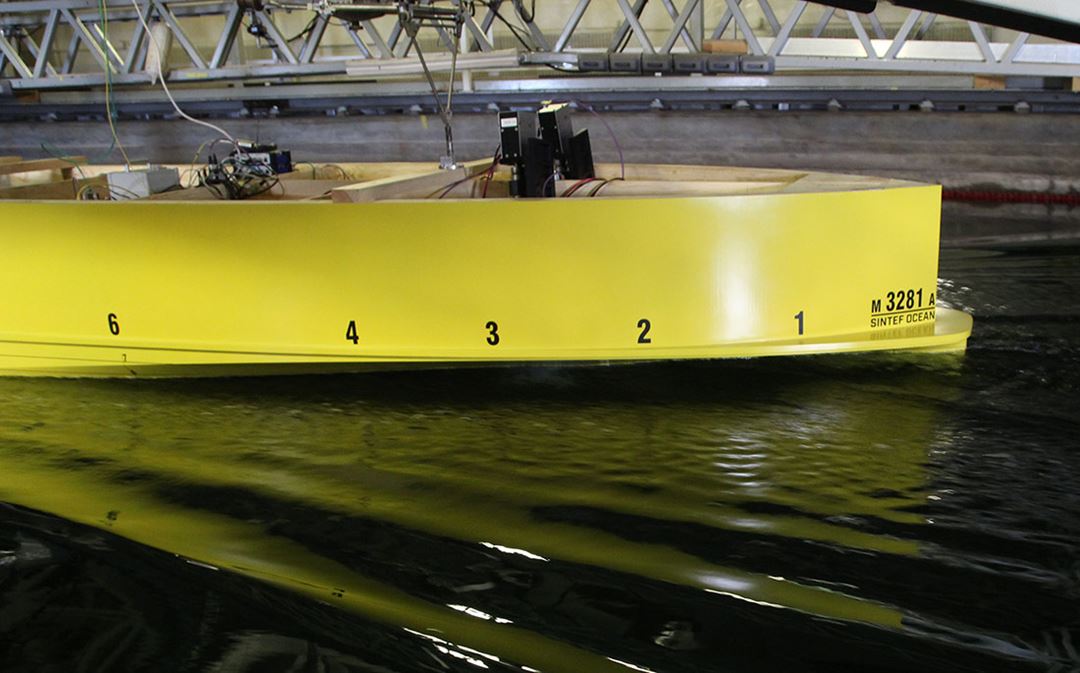Yellow ferry model with waves in the towing tank.