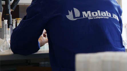 Mann med ryggen til, ikledd laboratoriefrakk