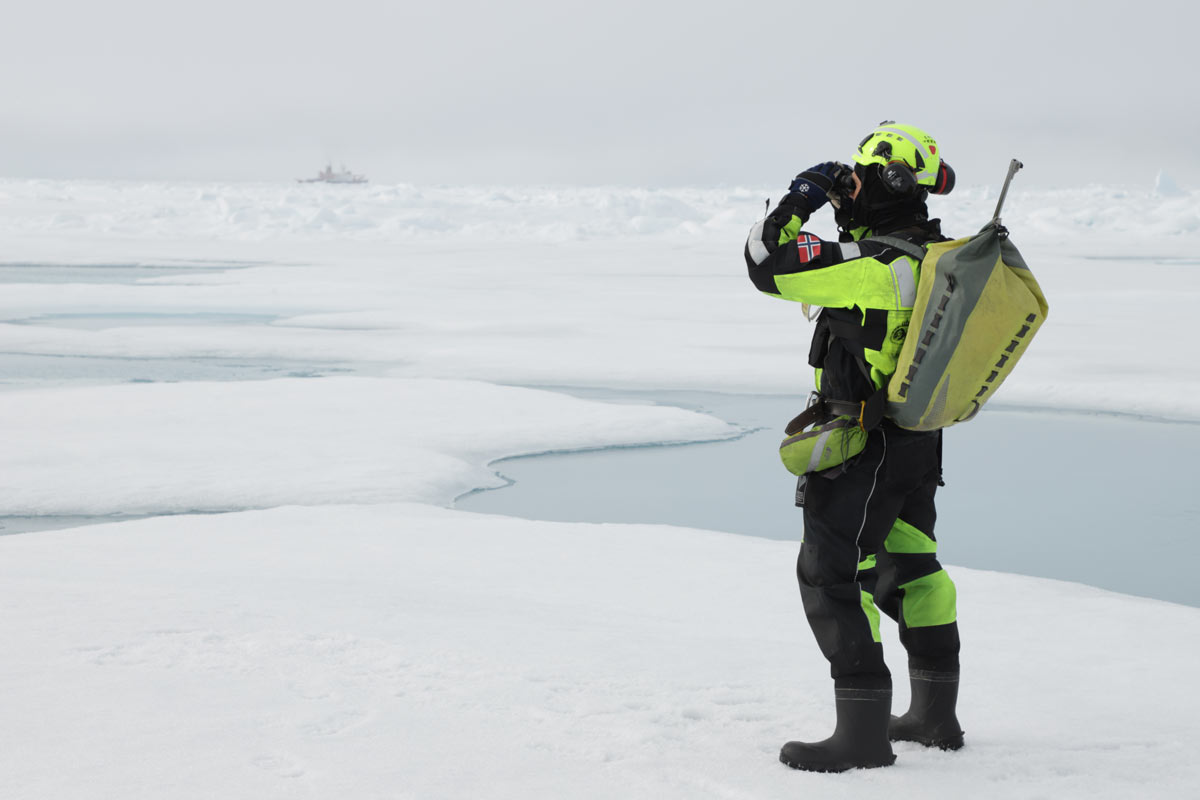 Eirik Hellerud (NP) er isbjørnvakt på isen, med Polarstern i bakgrunnen.