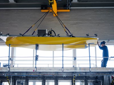 Yellow boat model being lowered into the cavitation tunnel