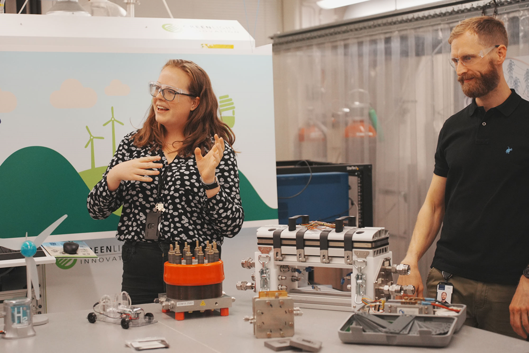 Katie McCay and John Trygve Angvik explain to students how hydrogen passes through a PEM fuel cell stack to create energy