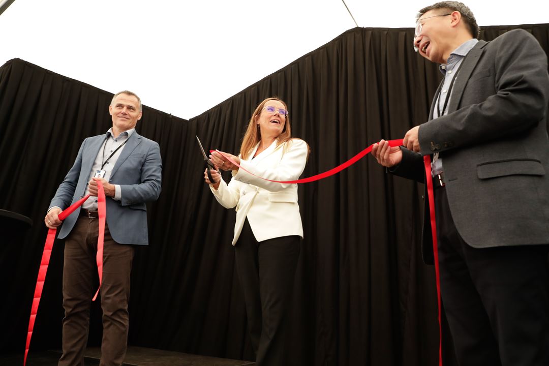 Three people on stage as the open
