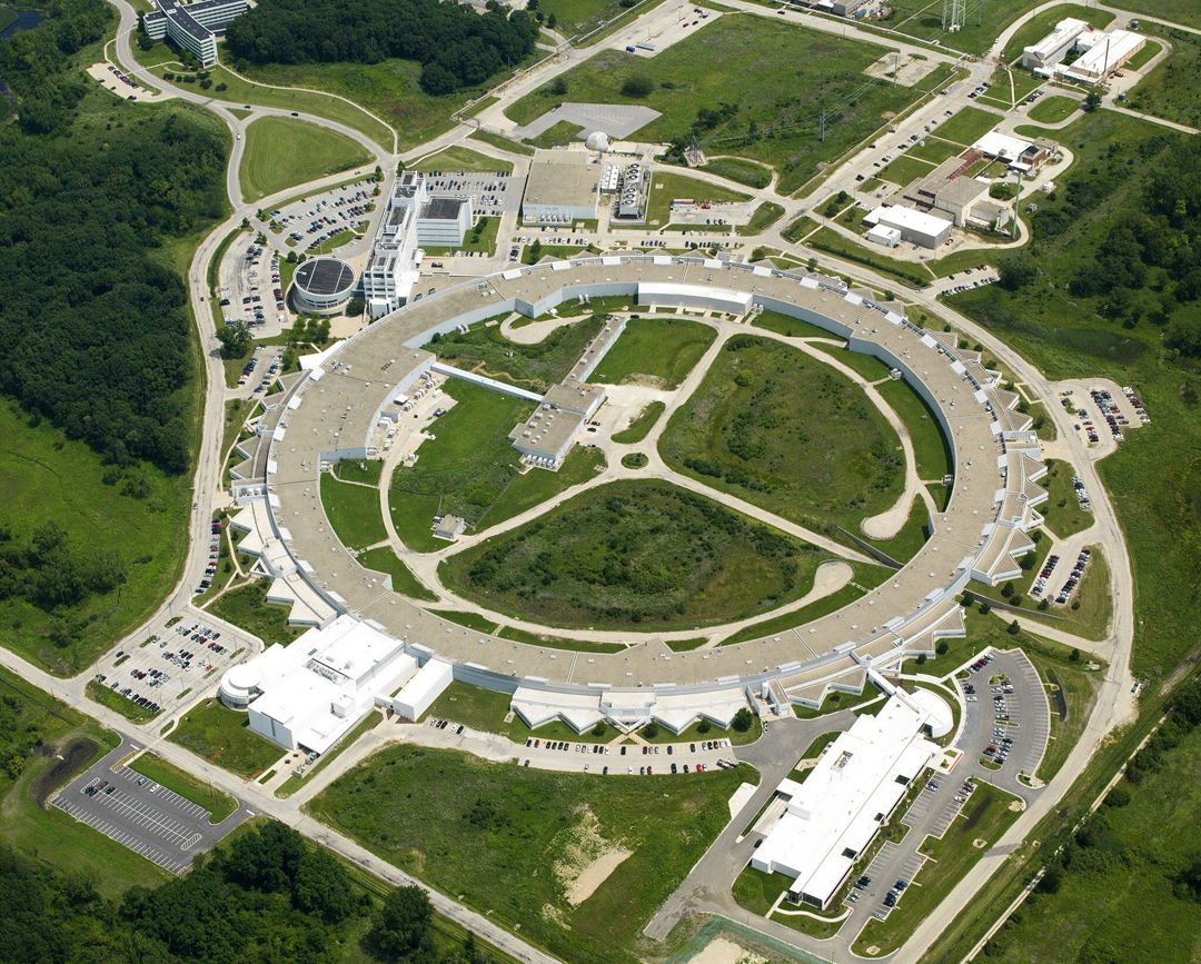 Luftfoto av stort sirkelrundt laboratorieanlegg som er en partikkel-akselerator.