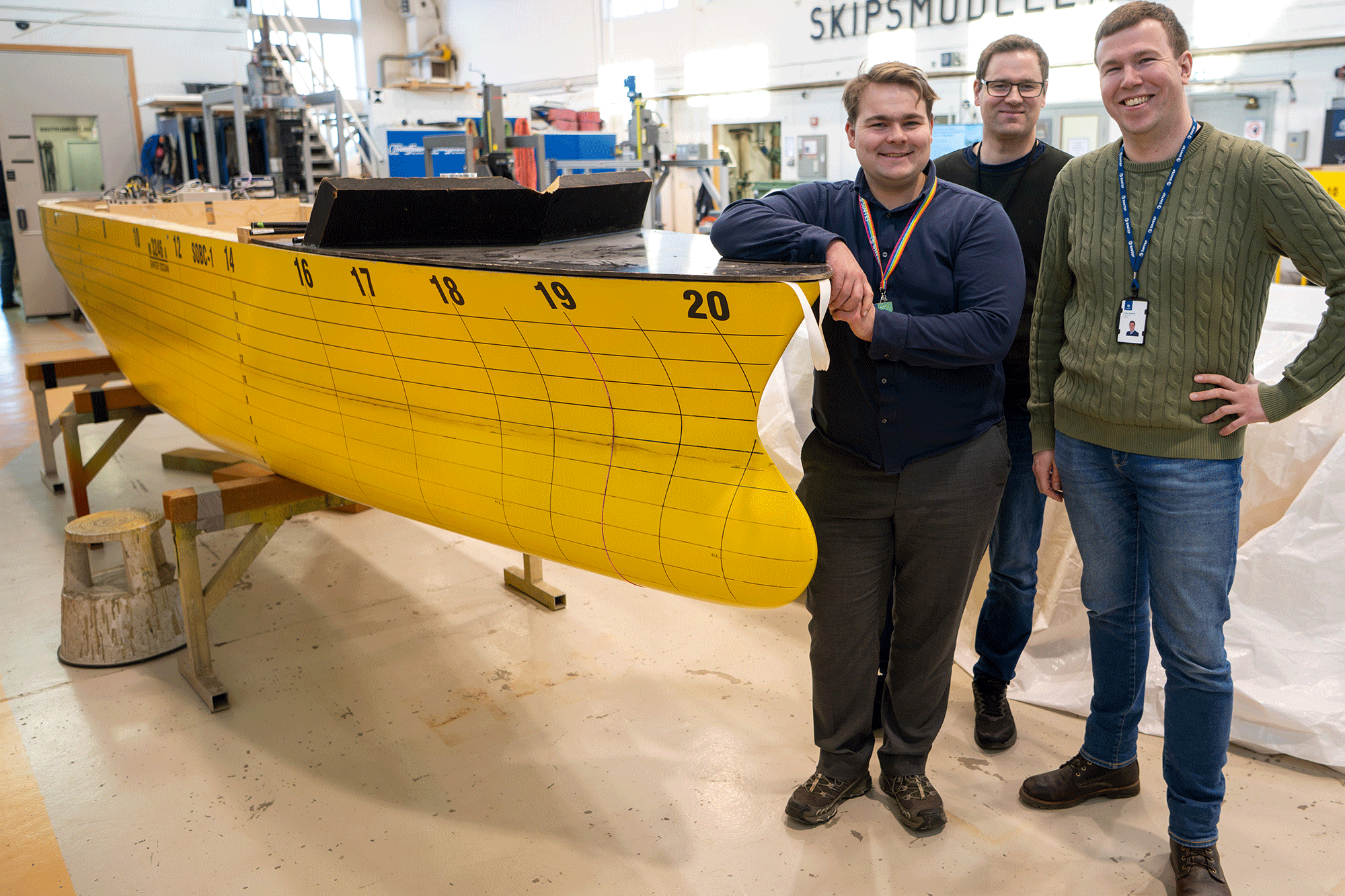 Researchers in front of a model boat