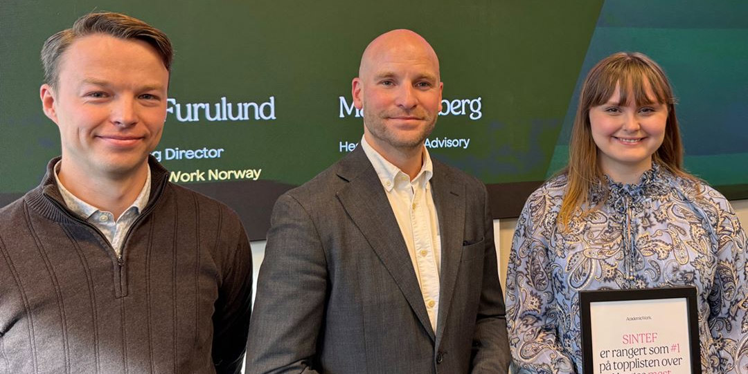 Prisvinnere flankert av YPAI-leder på scenen