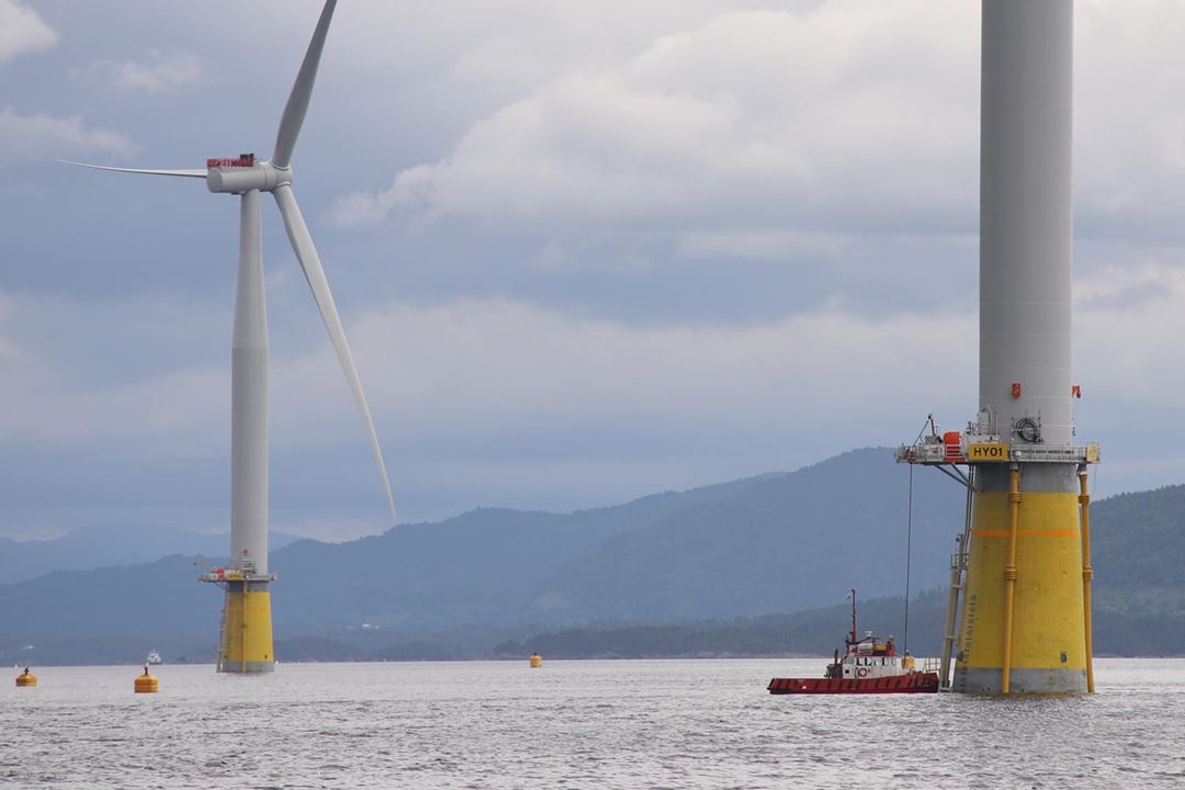 A boat carries out an operation close to an floating offshore wind turbine.