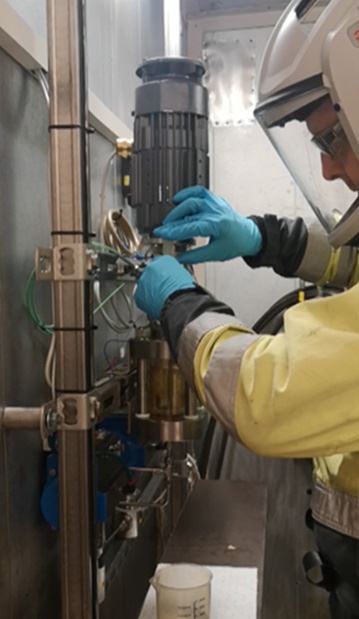 Person in protective equipment handles a machine