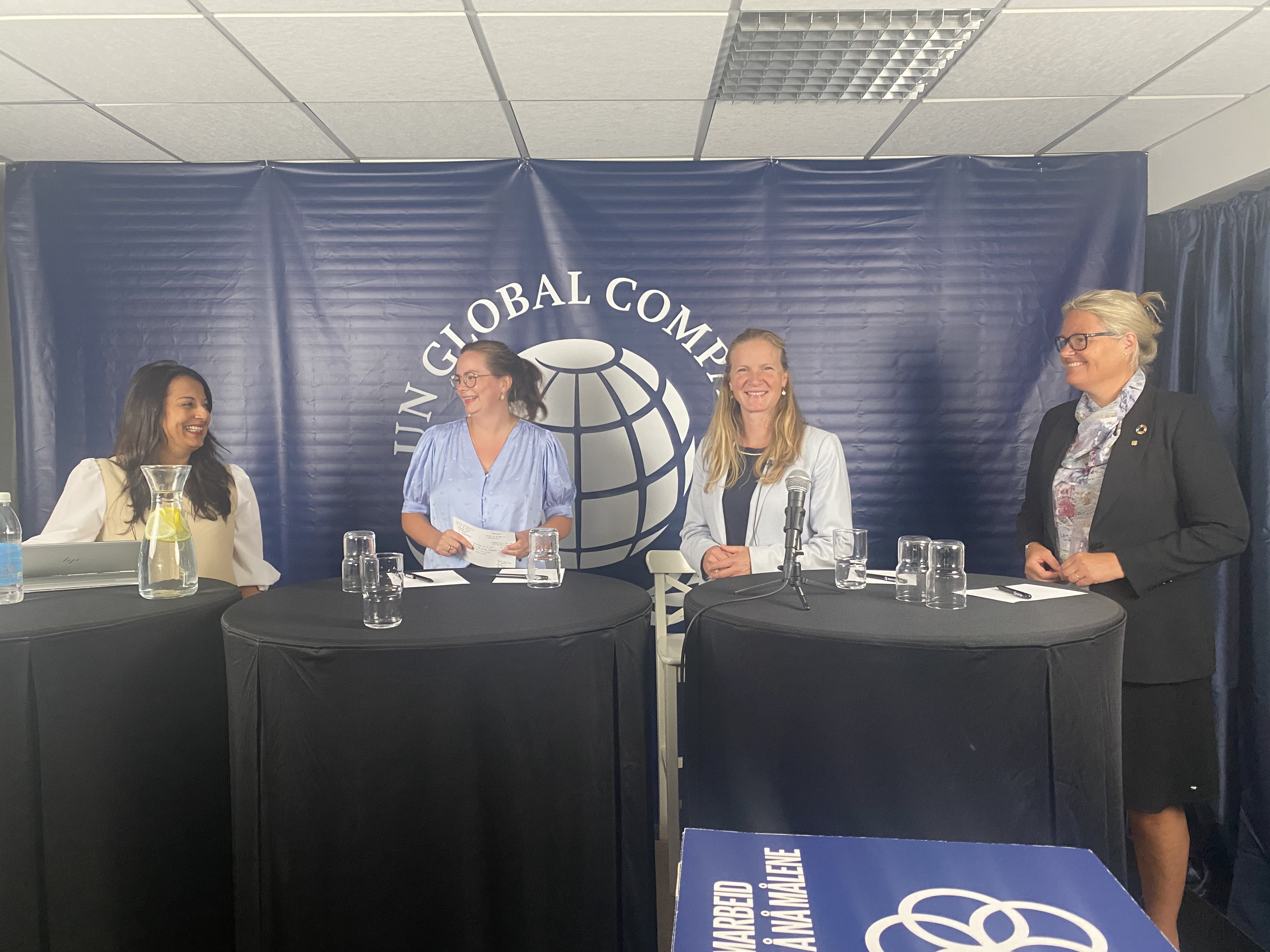 Fire kvinnelige paneldeltakere står på en scene.