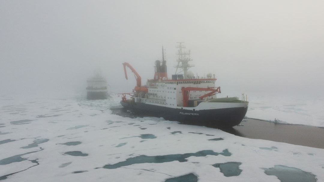 Kronprins Haakon og Polarstern stoppet ved isen, i nærheten av hverandre, i tåke. Foto: Christian Katlein (AWI)