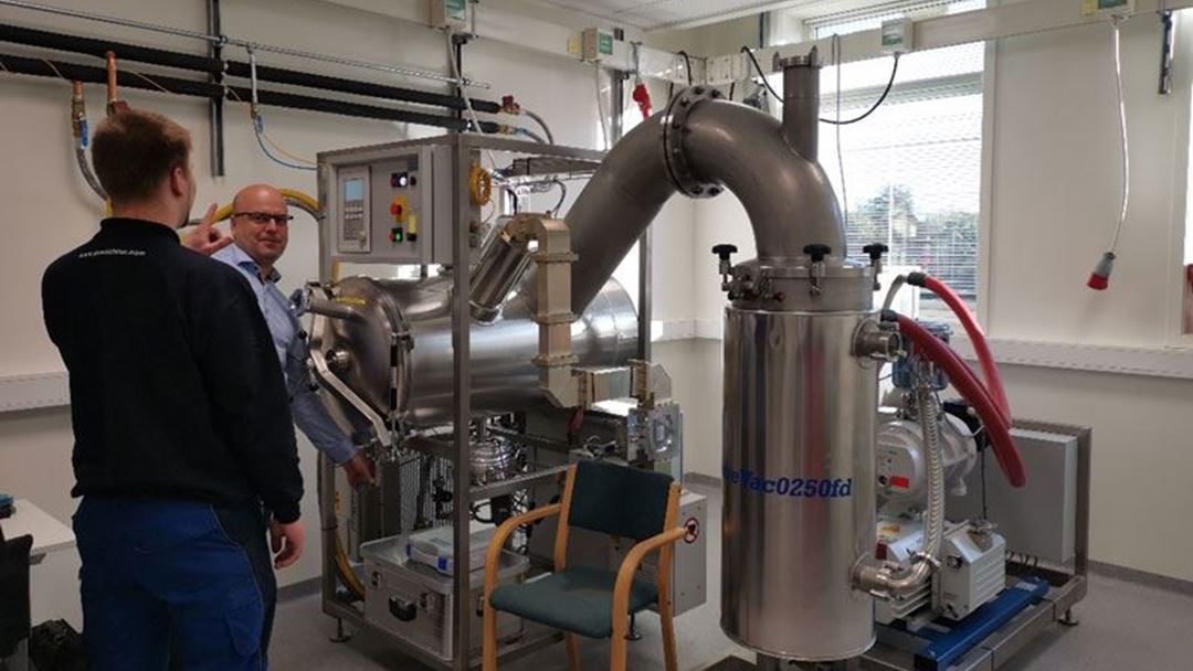 The microwave vacuum freeze-dryer seen after installation, with a technician from Puschner GmbH and senior research scientist Michael Bantle.
