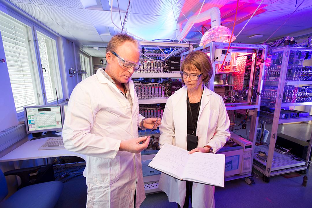Two scientists in white coats at the COMBI facility