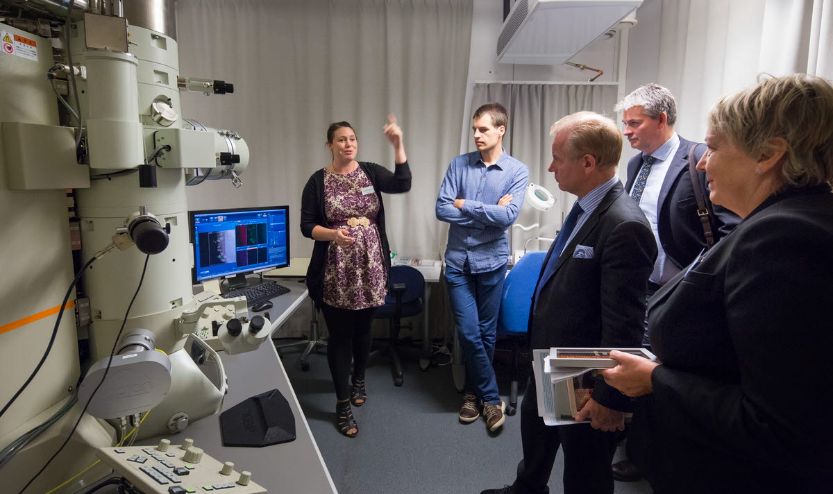 Gruppe mennesker foran elektronmikroskop