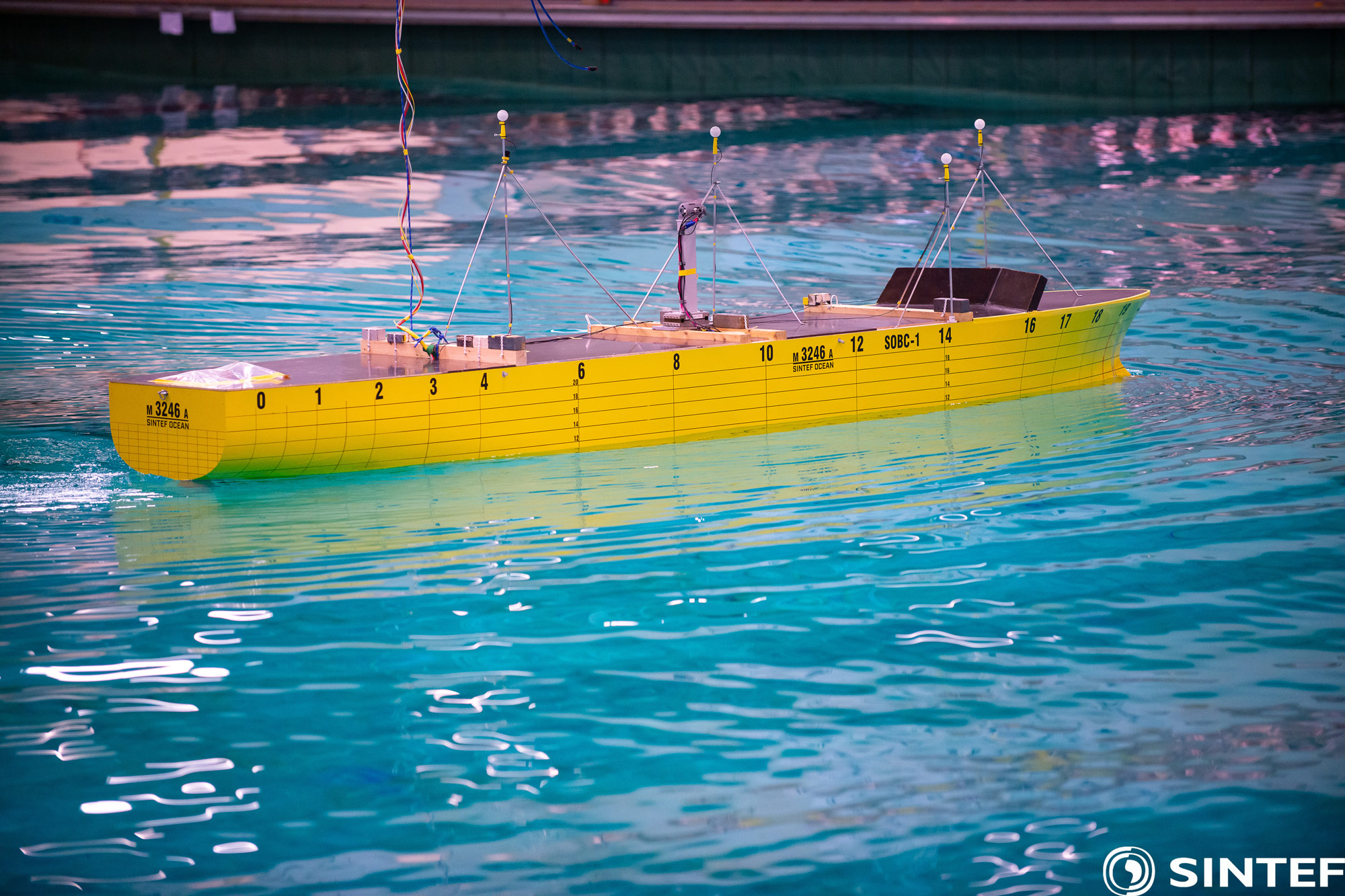 Yellow bulk carrier model in blue-green water.