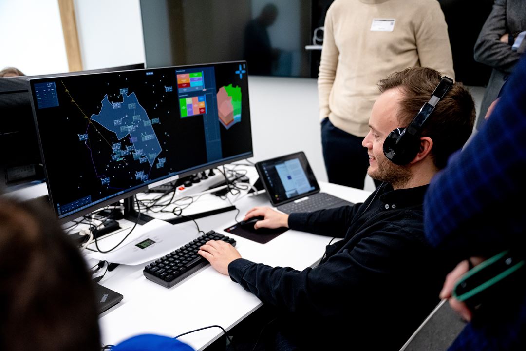 ATCO in front of screen showing air traffic.