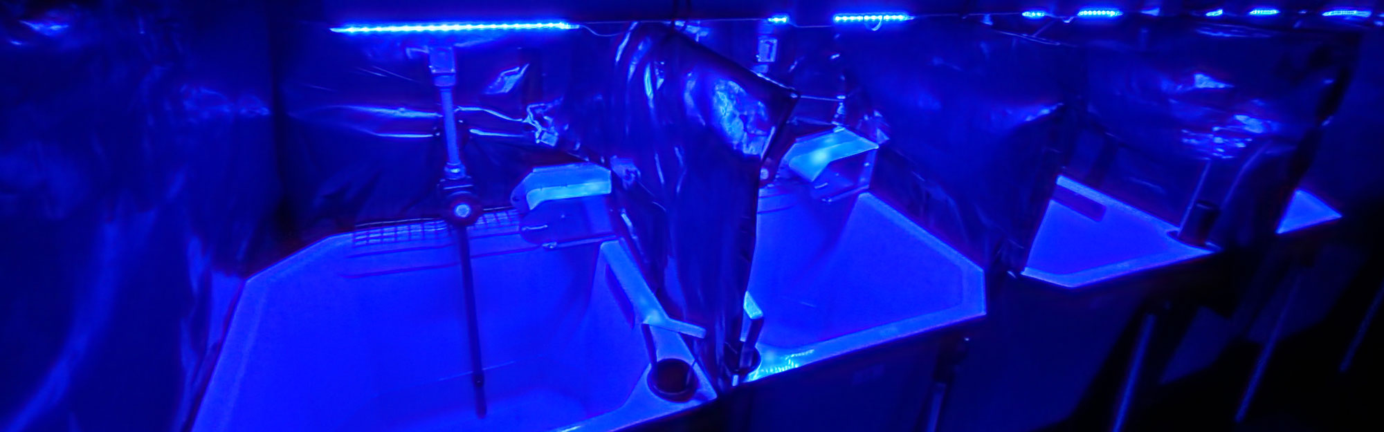 Row of sinks in blue light.