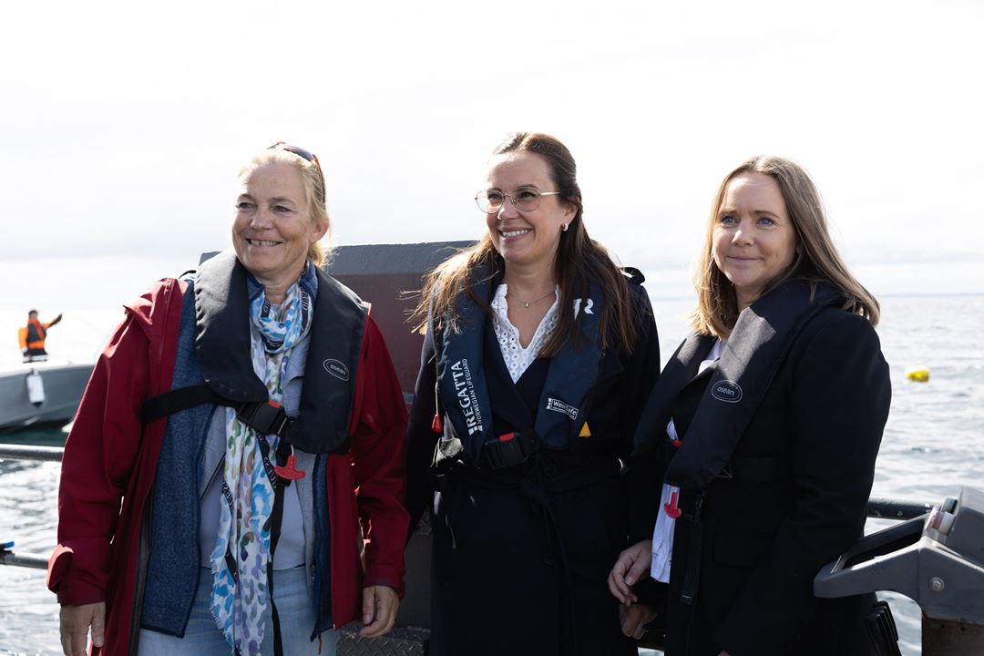 Tre damer med flytevester på båt