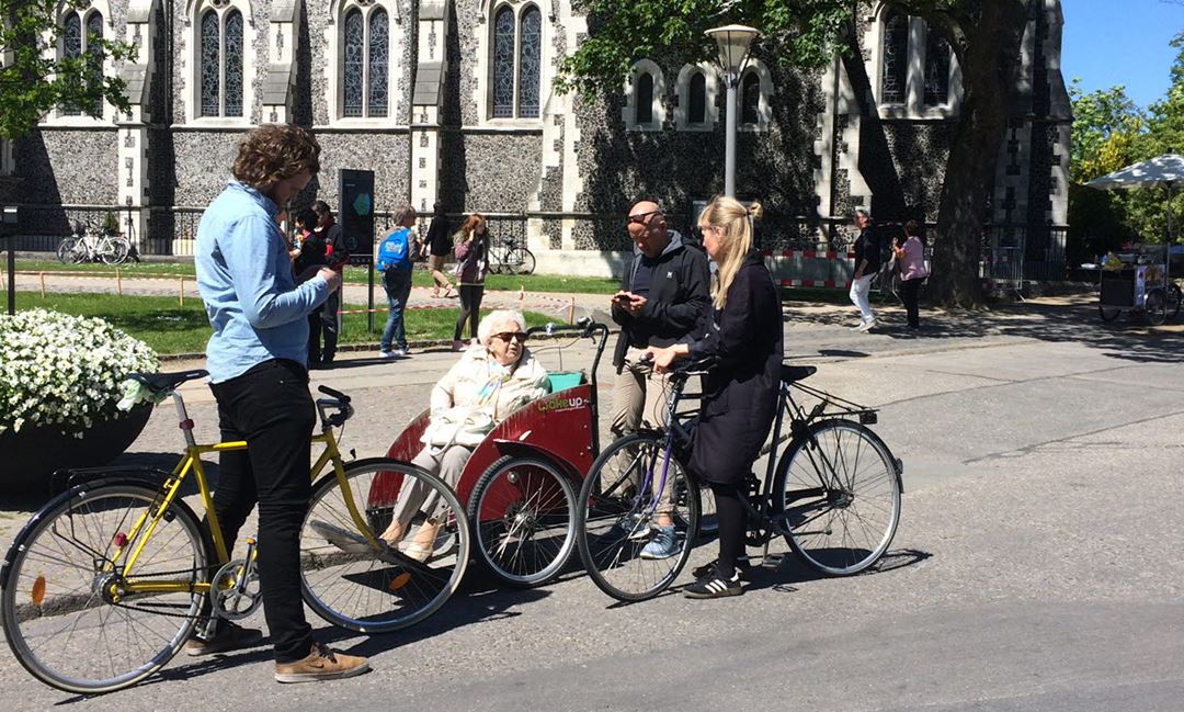Mennersker på sykkel, lastesykkel med passasjer