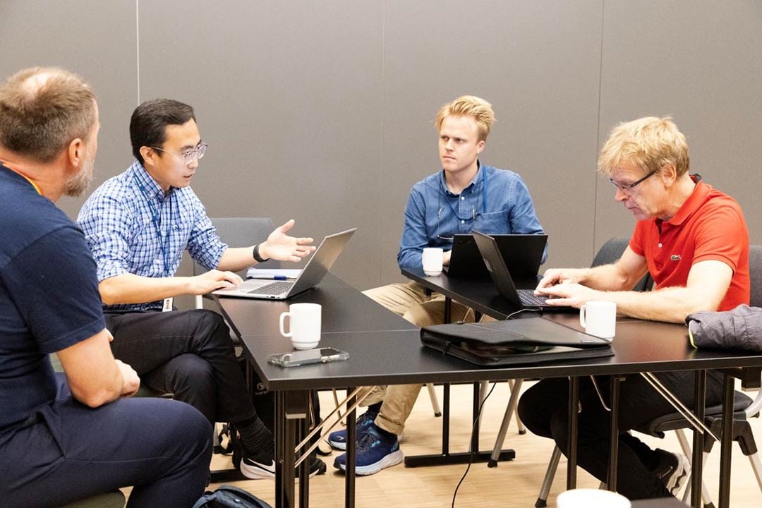 Four people sitting around a table, discussing.