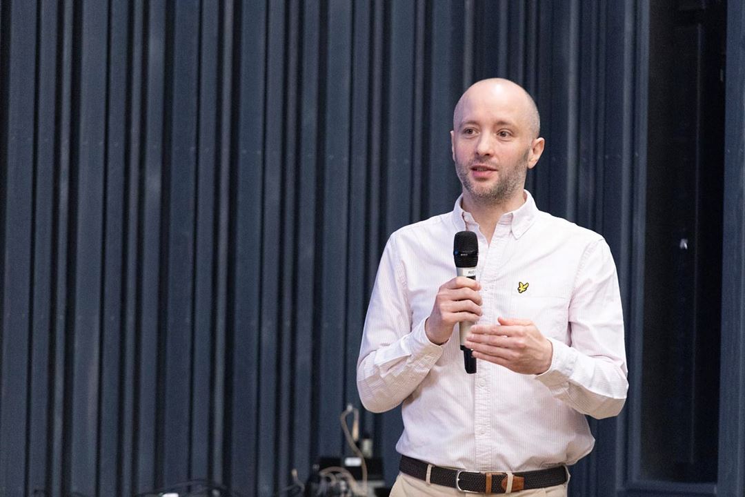 A person holding a microphone and talking.