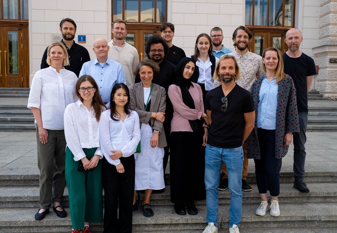 Partnere i prosjektet: 16 personer står på trapp foran et bygg