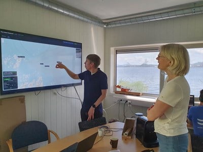 Martin Ludvigsen peker og forklarer på skjerm for Ingunn M Holmen.