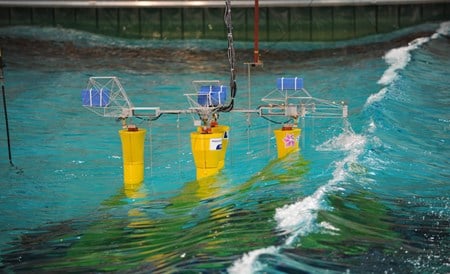 Tre gule fundamentmodeller i havbassenget med bølger