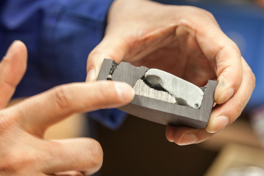Bildet vier innmaten av et batteri etter behandling med høytemperatur metallurgiske prosesser ved SINTEF. Separert ut i midten nederst, er en nikkel-og kobberlegering, mens slagget øverst til høyre inneholder sjeldne jorartsmetaller. Foto: Thor Nielsen/SINTEF