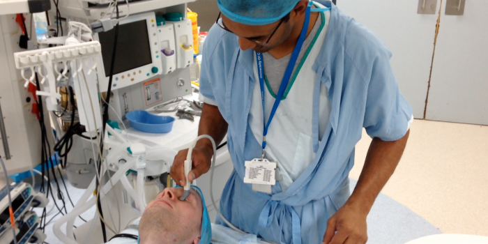 Den sør-afrikanske legen Llewellyn Padayachy tester ut ultralydutstyret med proben mot øyenlokket til pasienten. Foto: SINTEF.