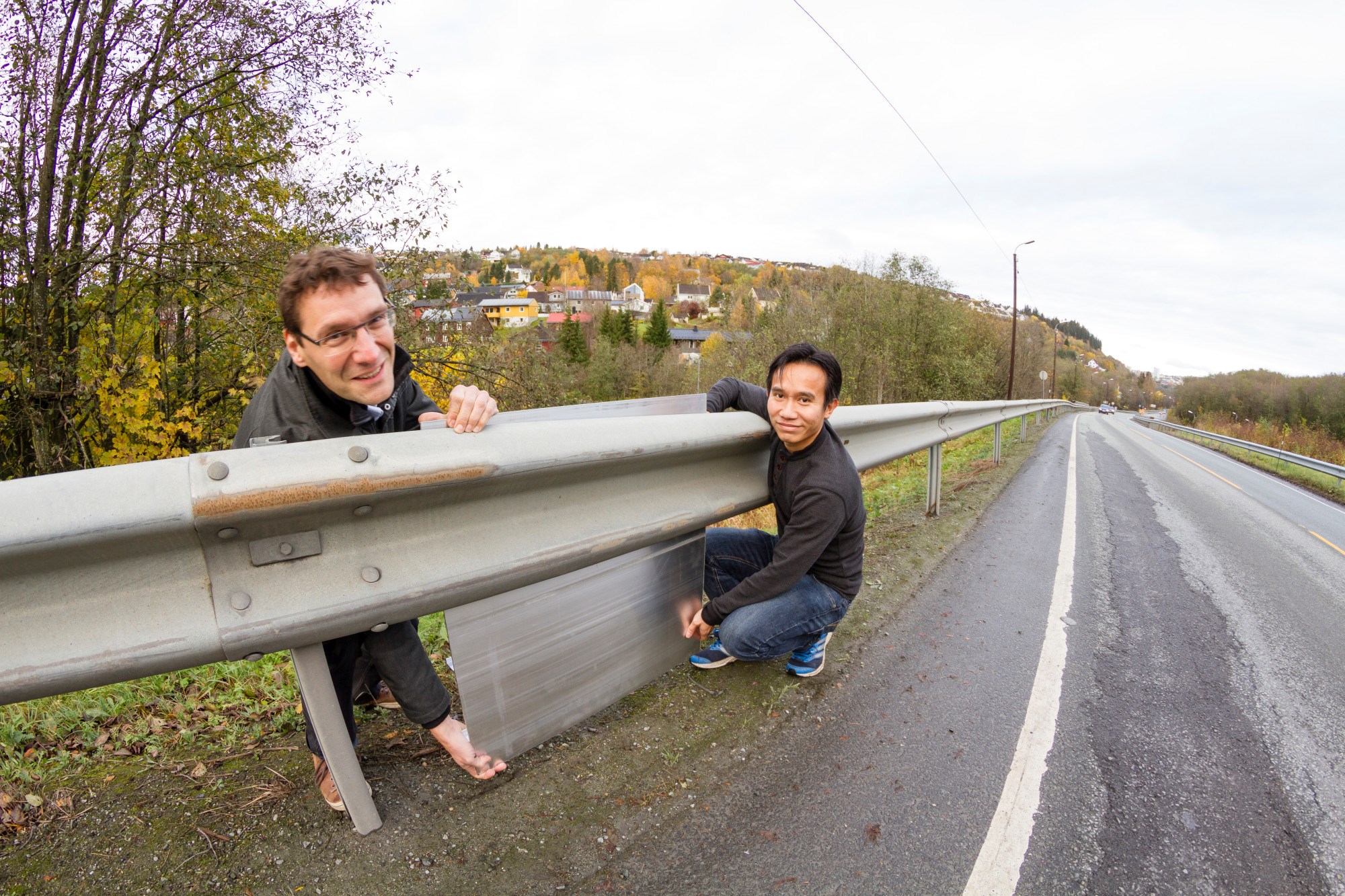 Vanlig autovern brukes blant annet der terrenget faller fra veien. Hus som skal støyskjermes her, ligger derfor oftest lavere enn støykilden. Med dette som bakteppe har SINTEF-duoen Dirk Nolte (til v.) og Nguyen Hieu Hoang utredet hvordan autovern kan kles med støyskjermer av aluminium. Foto: SINTEF / Thor Nielsen