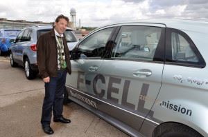 Mann fotografert foran grå personbil som har påskriften F-CELL i store bokstaver.