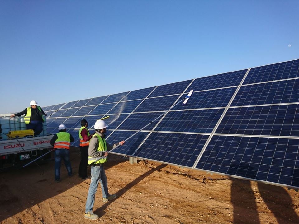 Her vaskes solcelleparken for hånd ved Scatec Solar sitt anlegg i Jordan. Men nå har forskere robotisert renholdet for å både spare vann og øke produktiviteten fra solkraftverk. Foto: Mohammad Ba’ra.