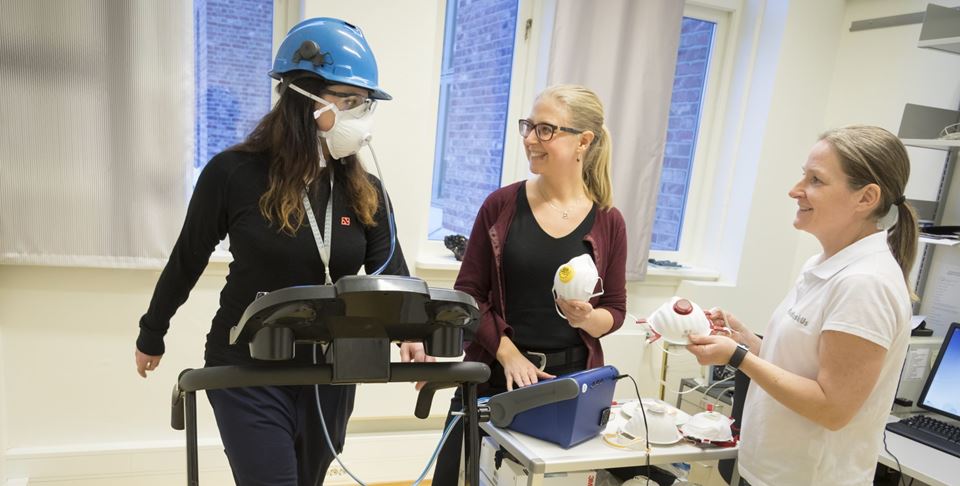 Her prøvekjøres testopplegg som er brukt til utprøving av støvmasker i "smelteverks-Norge". Yrkeshygieniker Solveig Føreland (til høyre) er ansvarlig for målingene, mens SINTEF-forsker Ida Teresia Kero er prosjektleder for det tverrfaglige prosjektet målingene inngår i. Testperson på tredemølla er SINTEFs Ida Eir Lauritzen. Foto: Thor Nielsen / SINTEF