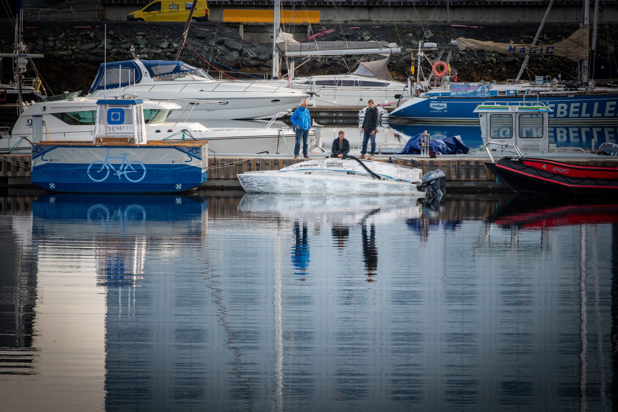 Giftfri miljøforkjemper: Denne båten kan operere ubemannet og bruker luft og vann i kampen mot oljesøl. Her flankert av de tre ansatte i Blue Impact AS. Fv. Stein Erik Sørstrøm, Karl Nevland og Børge Kjeldstad. Foto: Terje Svaar/Adresseavisen.