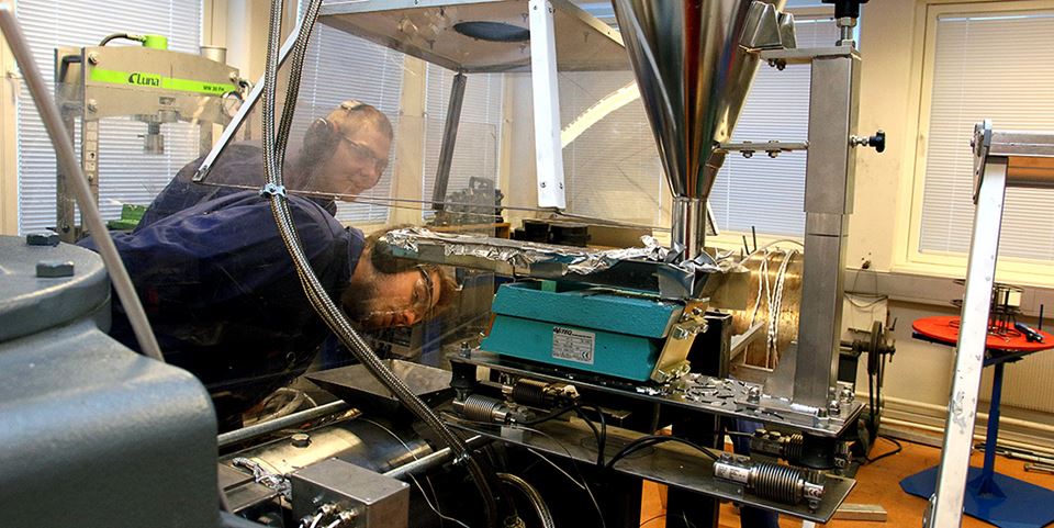 Denne maskinen maler opp aluminium til aluminiumsspon, som kan bli til aluminiumsarmering i betongkonstruksjoner. Det kan gi store klimafordeler. Geir Langelandsvik og Olav Ragnvaldsen  overvåker skrue-ekstruderen. Foto: Wenche Margrethe Kulmo/NTNU