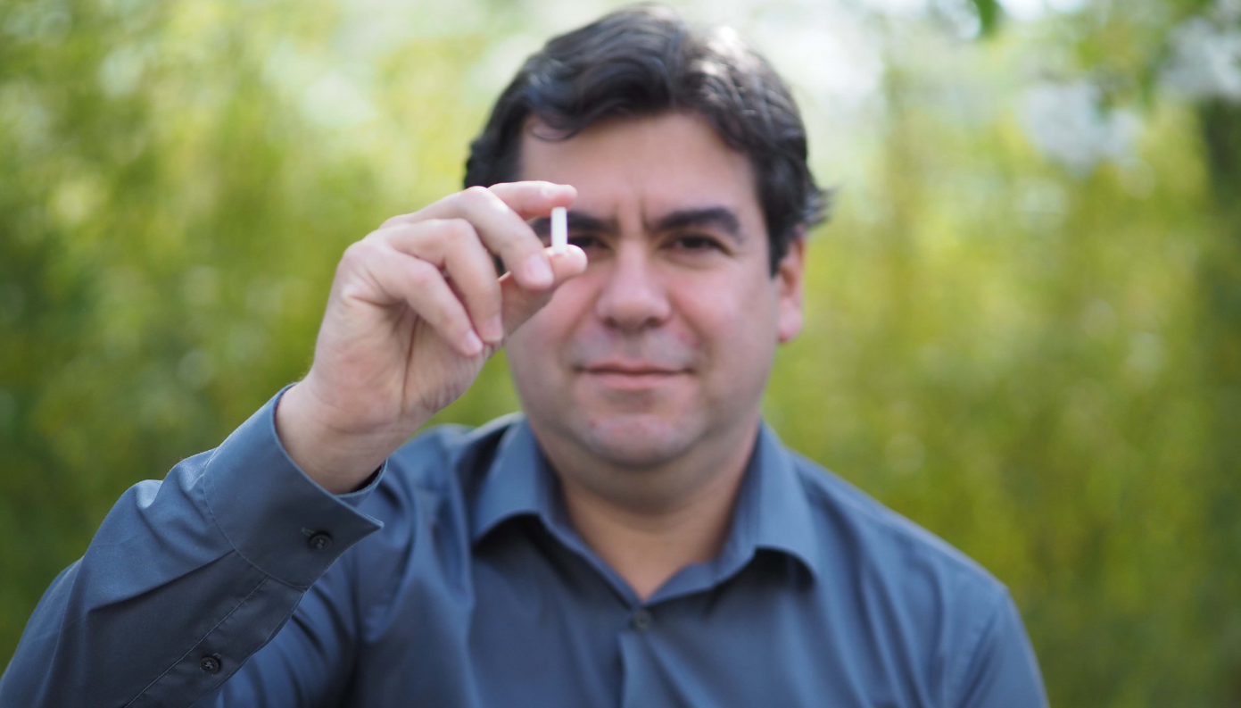 Liten og supereffektiv dings: SINTEF-forsker Carlos Grande viser fram den 3D-printede sylinderen som skal spille en viktig rolle i kampen for raskere framstilling av vaksiner. Foto: Privat utlån