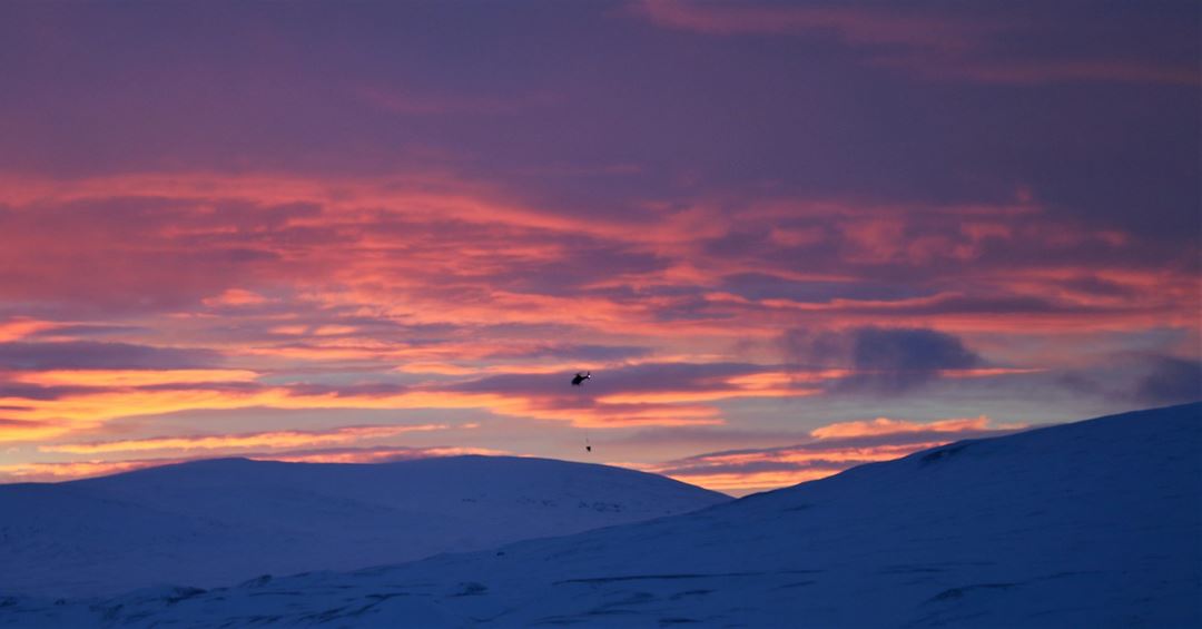 Helikoptertransport av betong i Troms på vinteren.