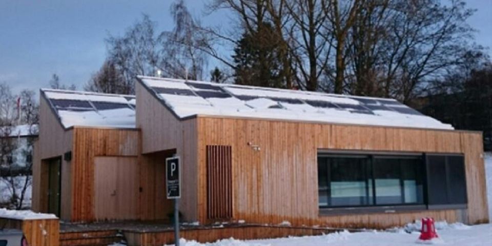 Solcellepanelene på taket av NTNUs ZEB Living Lab i Trondheim ble brukt som et casestudie for å finne ut hvor mye solenergi som går tapt på grunn av snødekket gjennom vintermånedene. Fotomontasje: NTNU