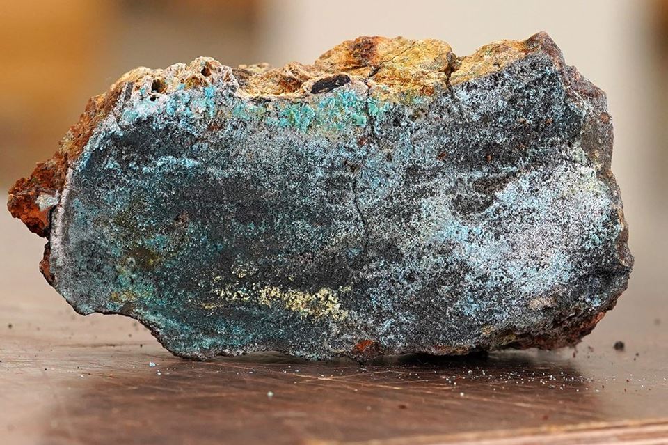 Dette er havbunnsmineraler på nært hold. En grønn utfelling av kobbermineral ses her i en gjennomskåret sulfidprøve, hentet opp fra Sokkeldirektoratets tokt på Mohnsryggen i Norskehavet i 2020. Foto: Øystein Leiknes Nag/Sokkeldirektoratet