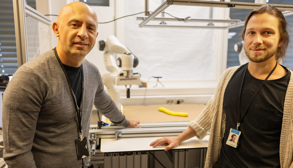 I laben: Forskerne Ekrem Misimi (t.v.) og Sverre Herland foran roboten Bifrost, som nå har satt verdensrekord i å lære seg forming av myke objekter "på egen hånd". Foto: Henriette Louise Krogness