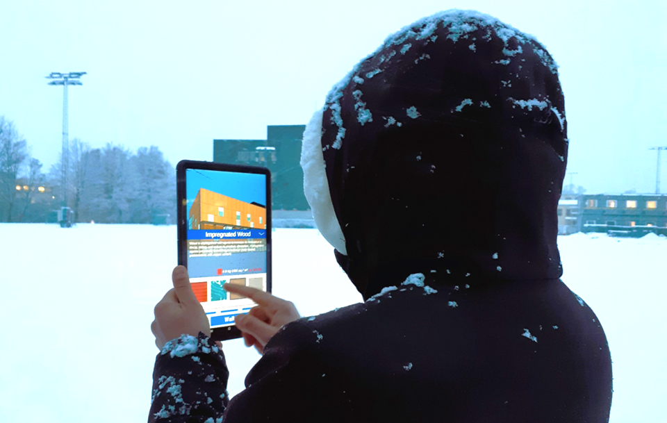 Deltakerne i studien brukte en AR-app på Voldsløkka skole og kulturstasjon i Oslo, for å se for seg hvordan en bygning kan bli med ulike fasadematerialer med forskjellig klimafotavtrykk. Foto: SINTEF
